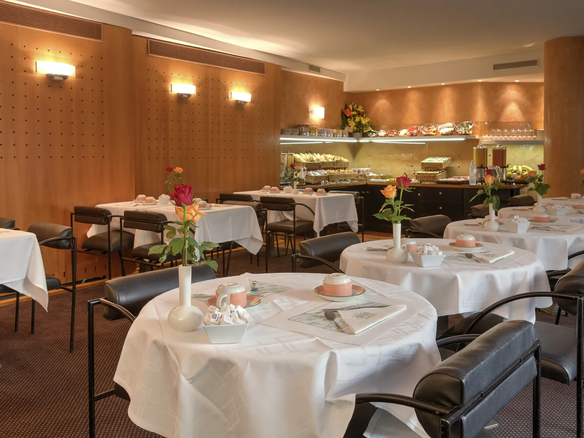 Frühstücksraum mit gedeckten Tischen und warmem Holz