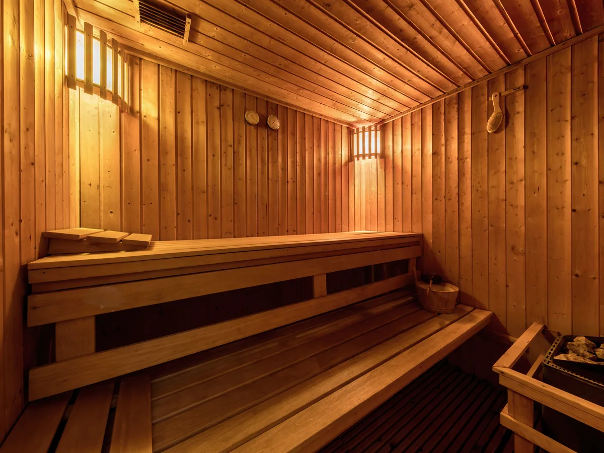 Finnische Sauna mit hellem Holz und weicher Hintergrundbeleuchtung